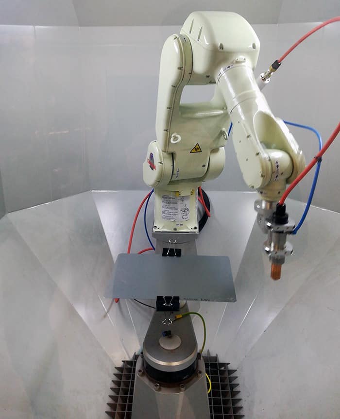 A robotic plasmabrush PB3 system with fixed steel sheet ready for operation to improve the bonding properties of pressure-sensitive adhesives on white goods